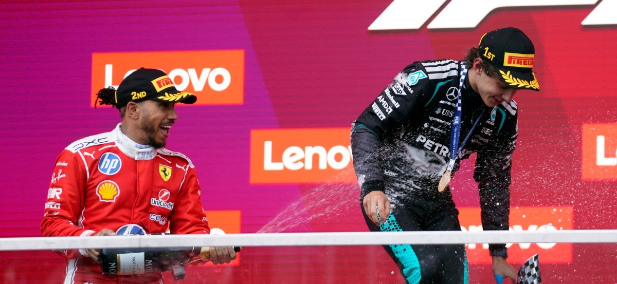 Wedren-wenner Kimi Antonelli van Mercedes word met sjampanje gespuit deur Ferrari se Britse jaer, Lewis Hamilton, wat tweede geëindig het.