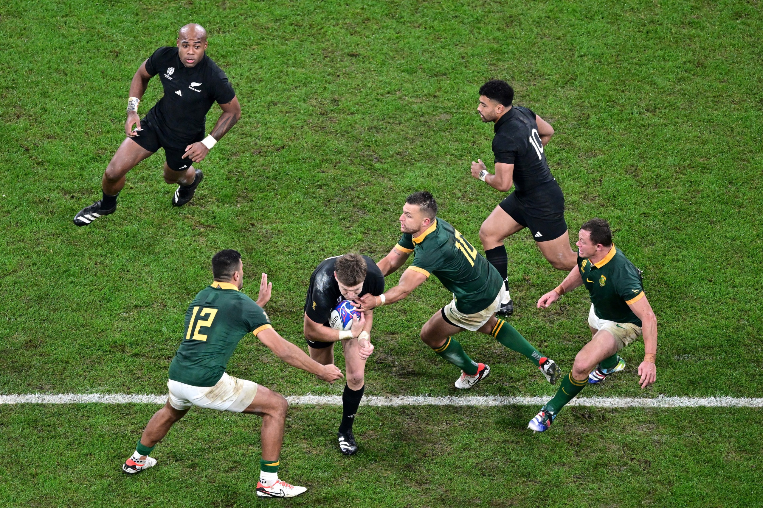 Bokke Handré Pollard en Damian de Allende lak ’n Kiwi tydens die Rugbywêreldbeker-eindstryd in 2023.
